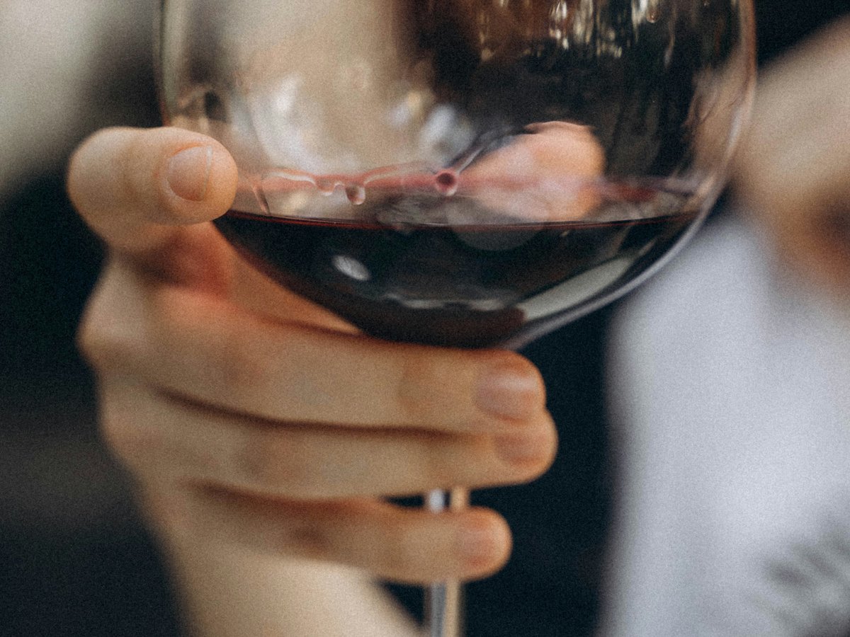 Main tenant un verre de vin